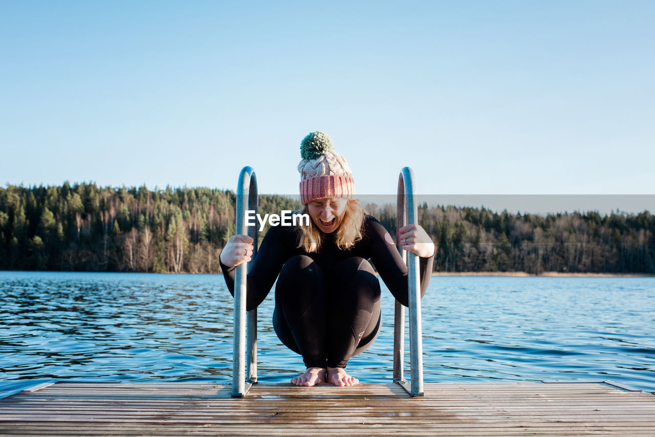 Woman looking nervous about cold water ice swimming in sweden