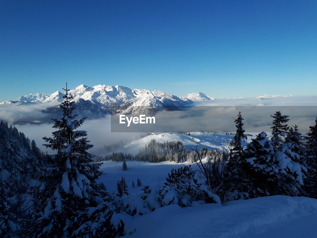 Scenic view of snowcapped mountains against clear blue sky