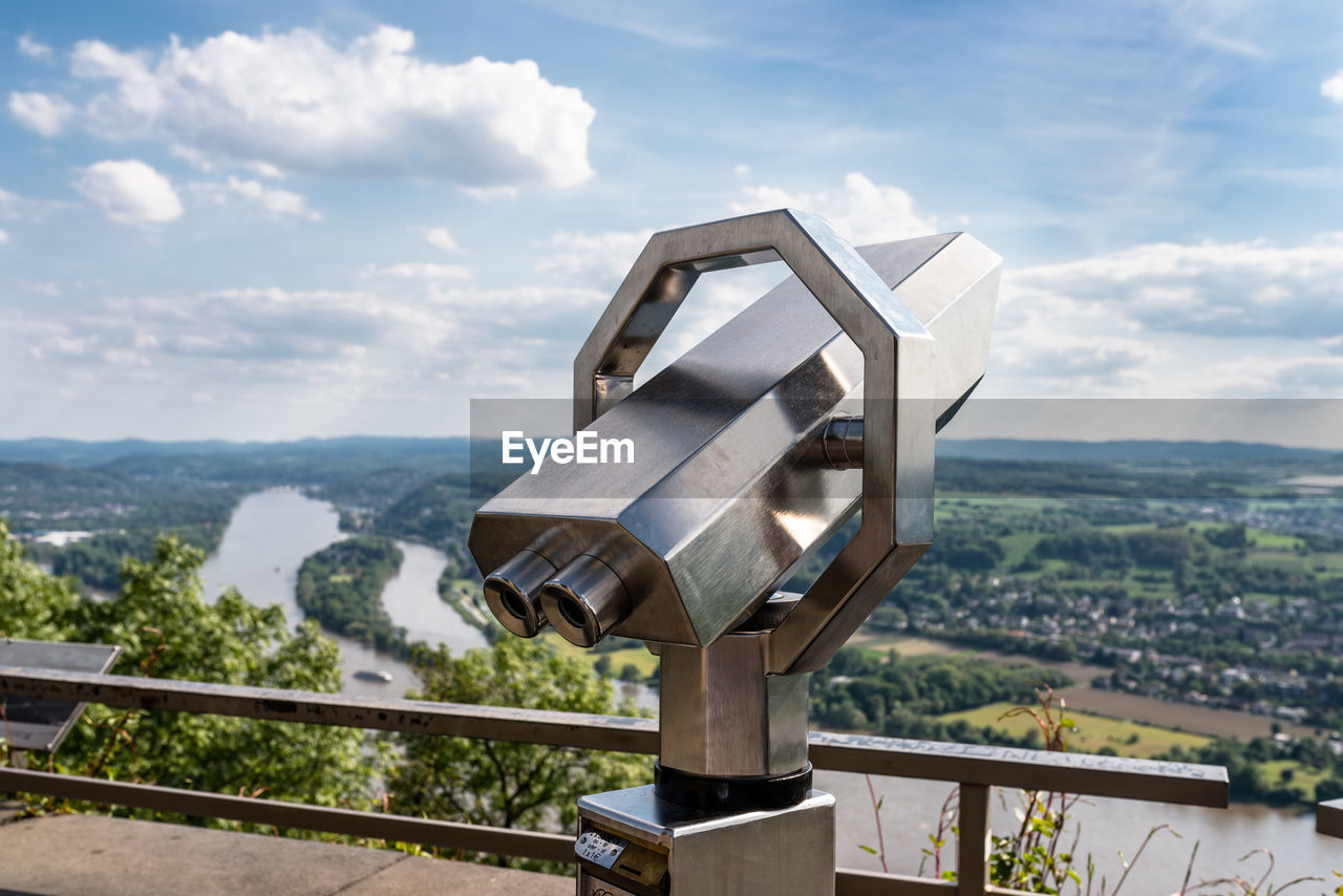 A paid binocular telescope, set on a high vantage point with a view of the city.