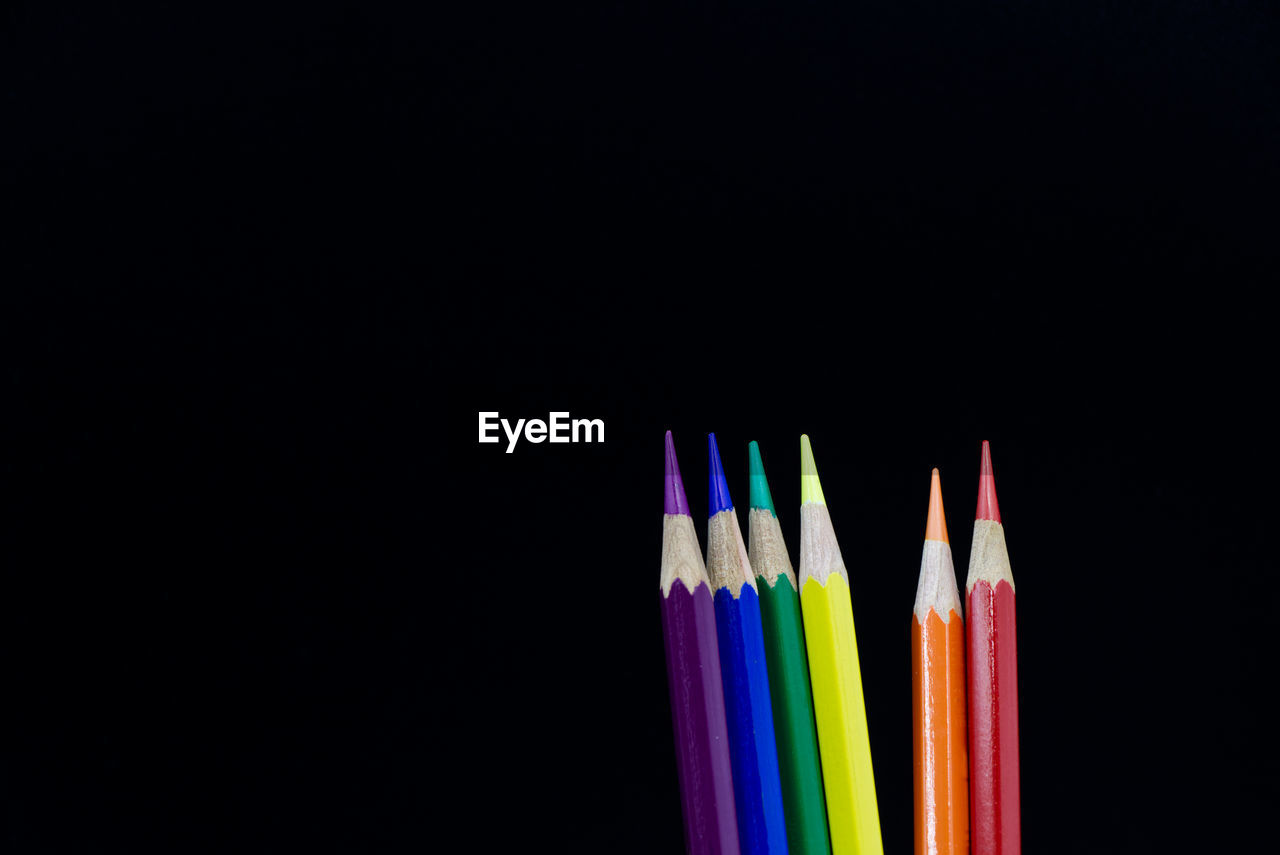 close-up of colored pencils over black background