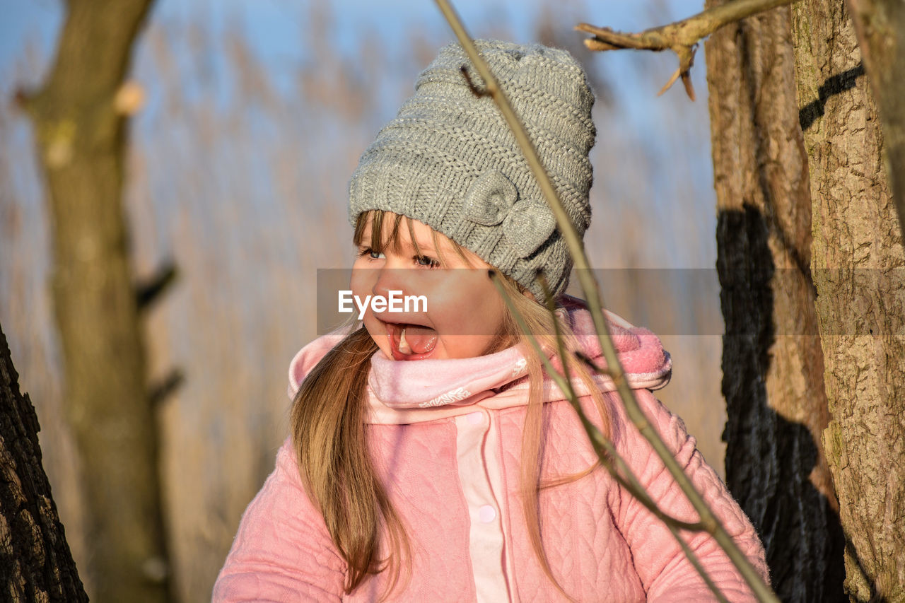 Cute girl screaming while standing by tree