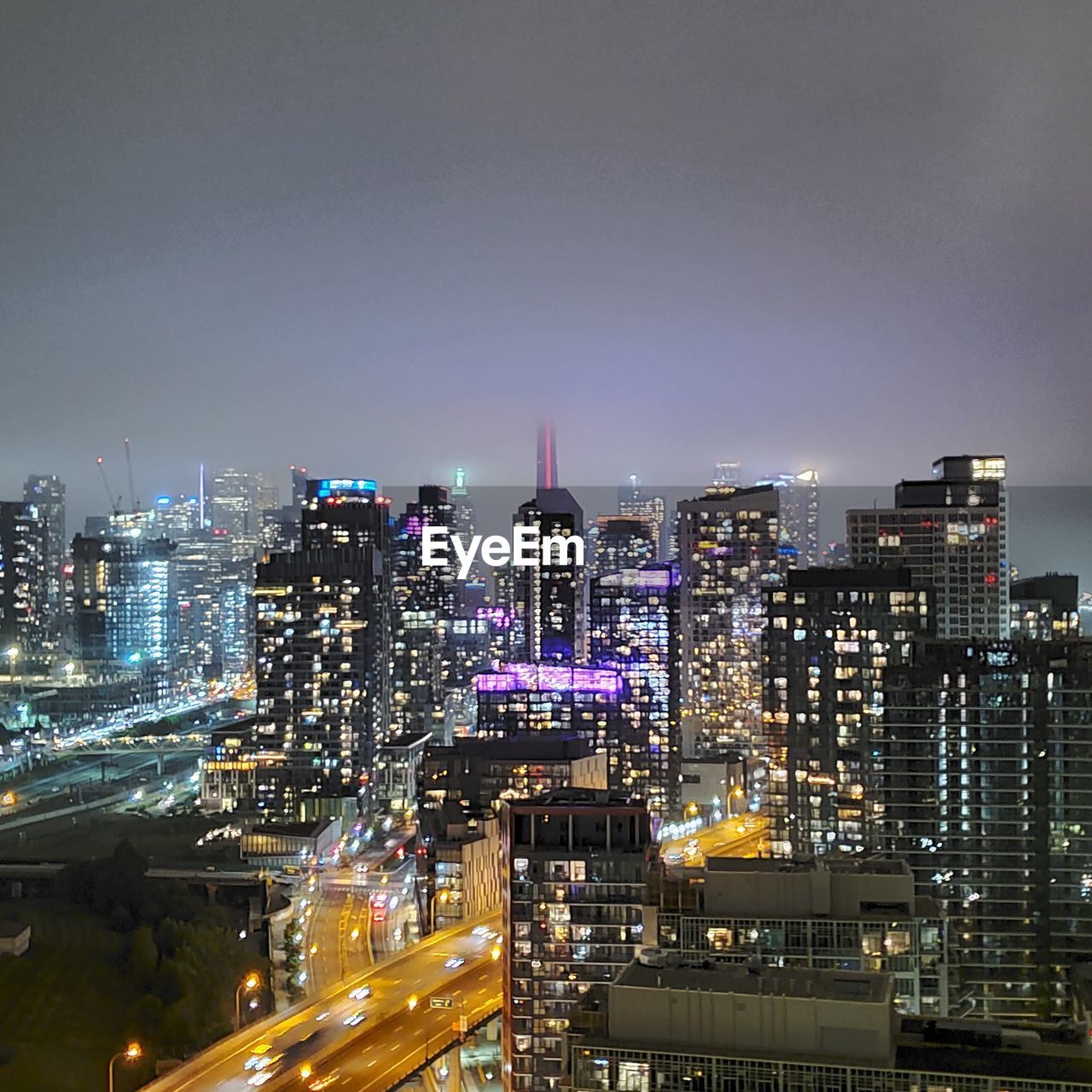 Illuminated buildings in city against sky at night