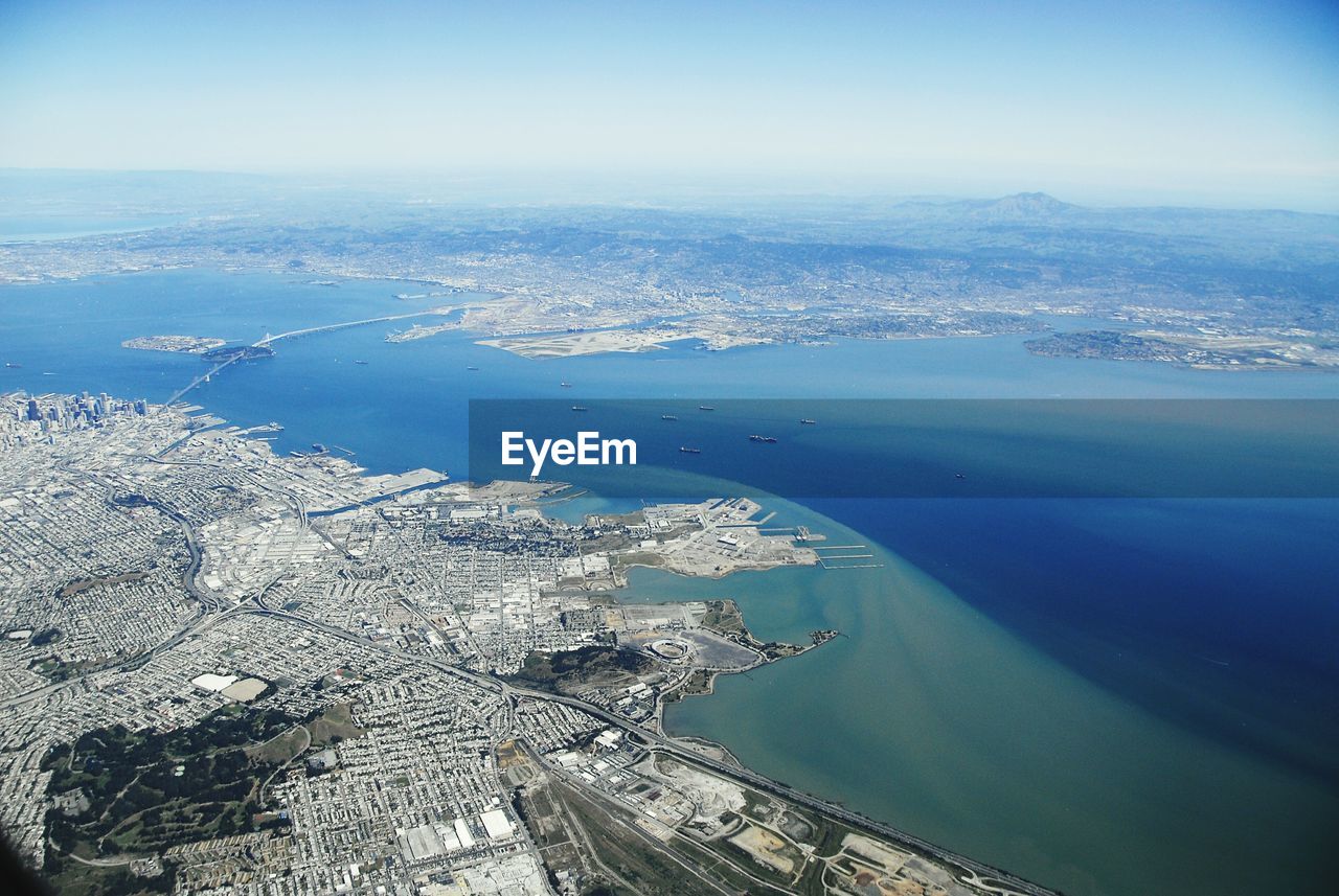 Aerial view of cityscape and bay against sky