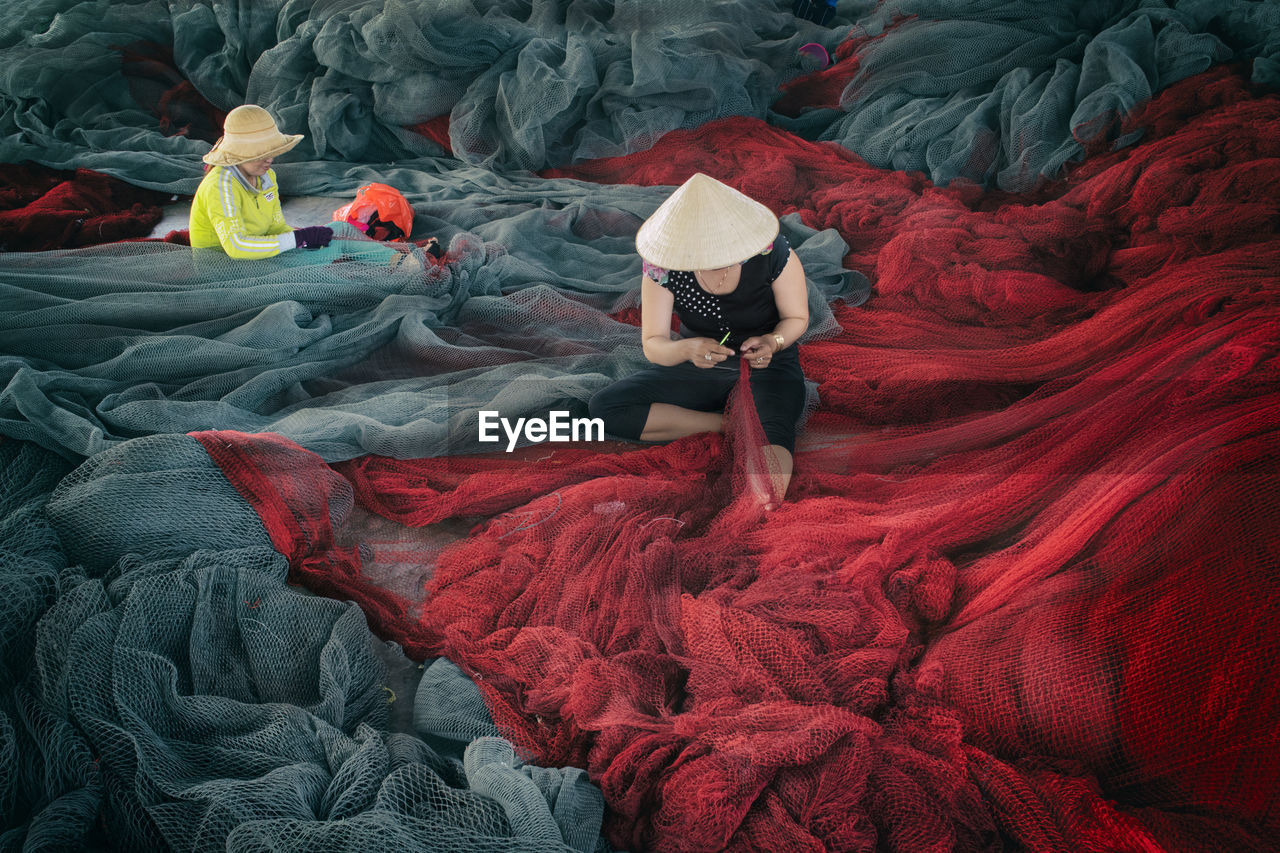 HIGH ANGLE VIEW OF WOMAN RELAXING ON RED CARPET