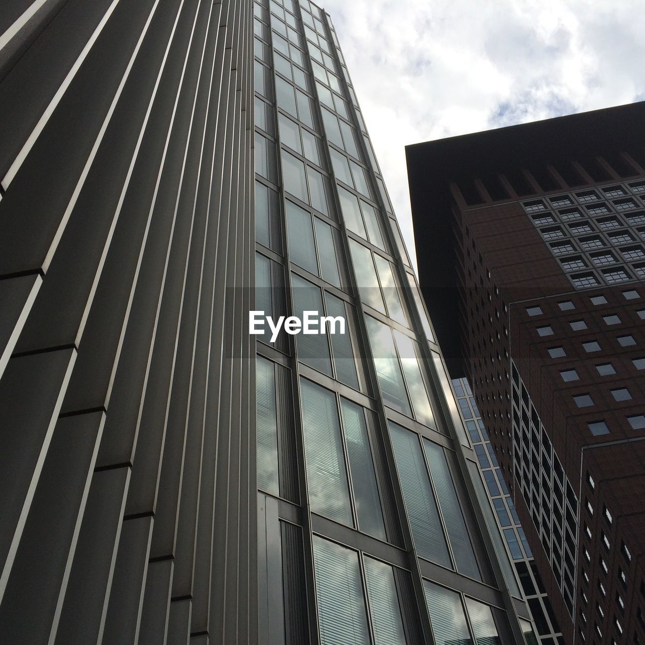 Low angle view of modern building against cloudy sky