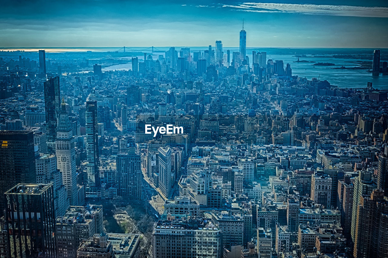 HIGH ANGLE VIEW OF ILLUMINATED CITYSCAPE AGAINST SKY