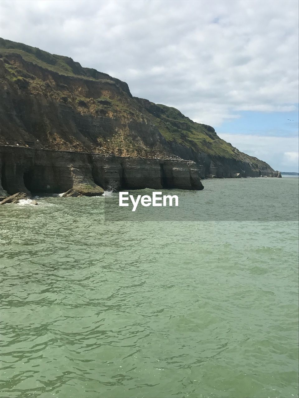 SCENIC VIEW OF SEA BY MOUNTAIN AGAINST SKY