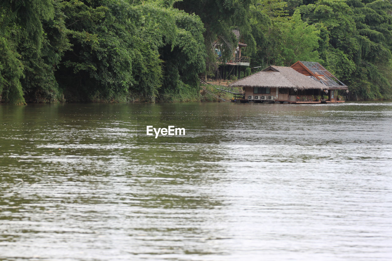 SCENIC VIEW OF LAKE BY TREES AND HOUSES