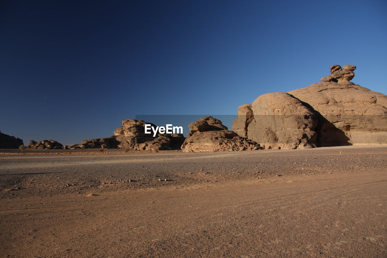 Rock formations in desert against clear blue sky