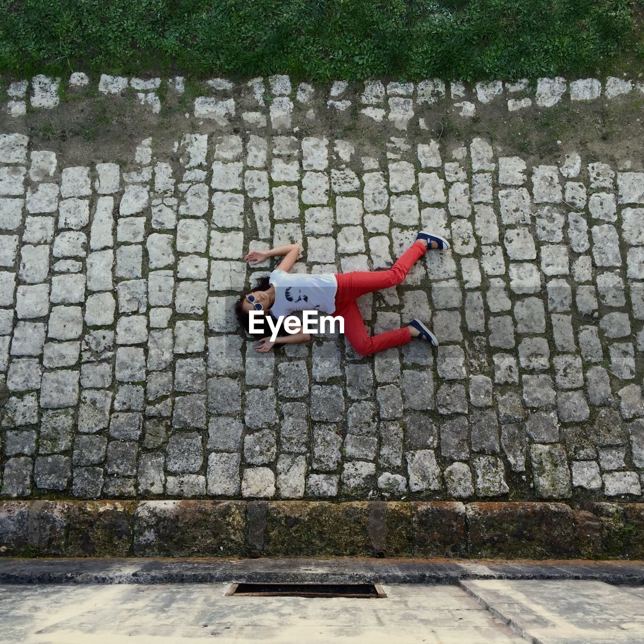 High angle view of girl lying on street 