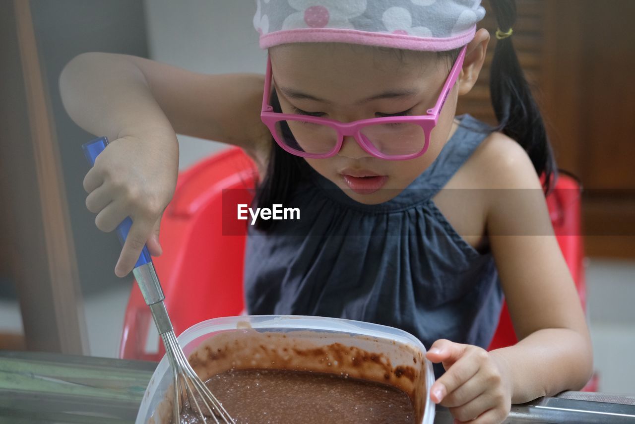 Close-up of cute girl preparing food on table