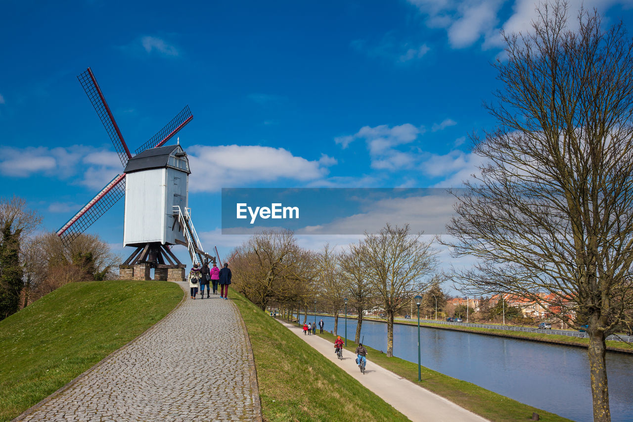 TRADITIONAL WINDMILL BY PLANTS AGAINST SKY