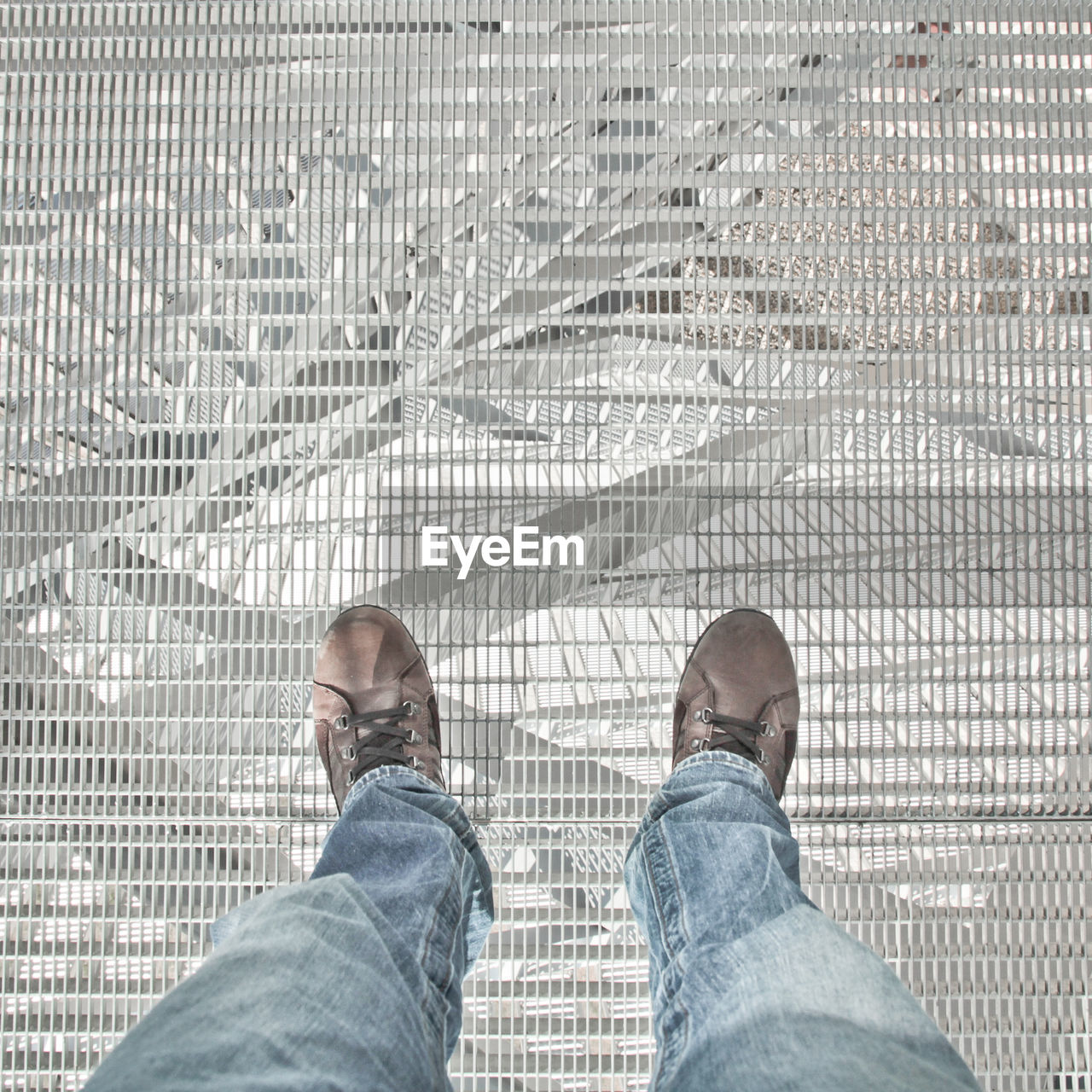 Low section of man standing on metal grate