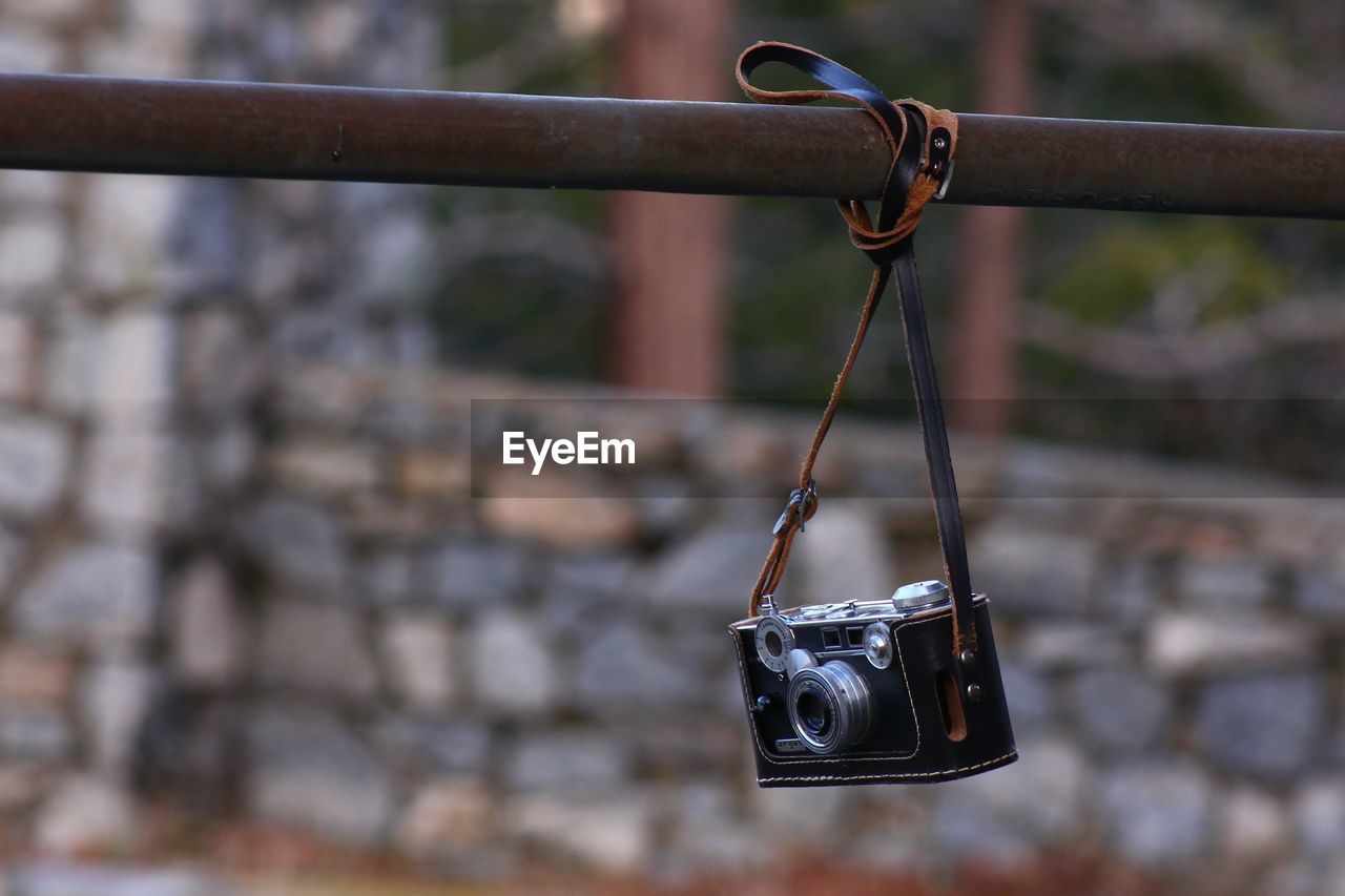 Close-up of camera hanging on rusty metal