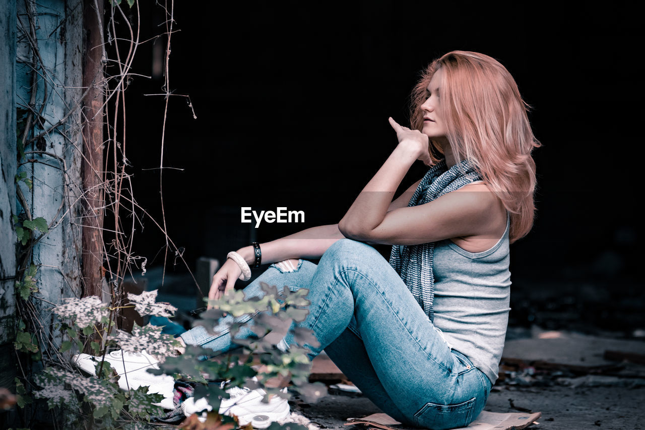 Beautiful young looking away woman sitting outdoors