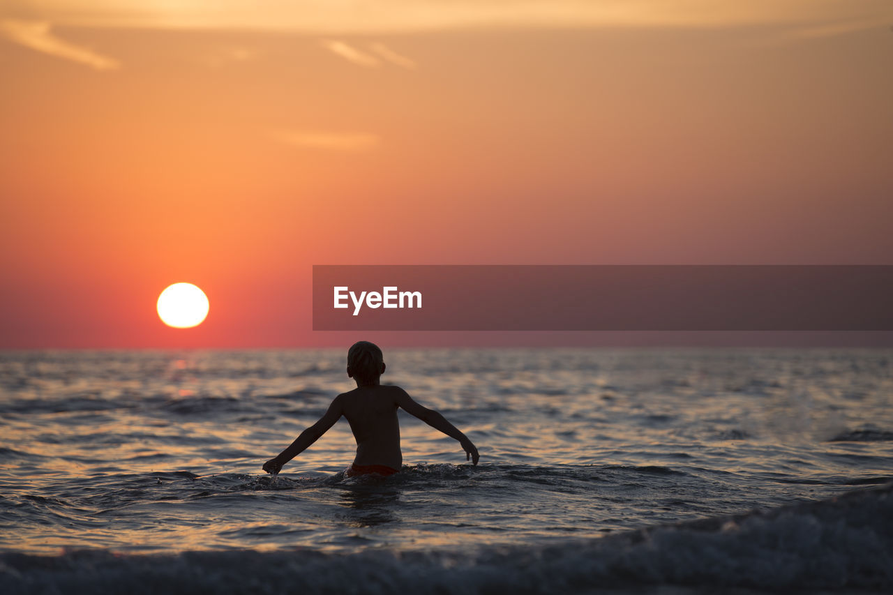 Sunset modeled with a child on the beach