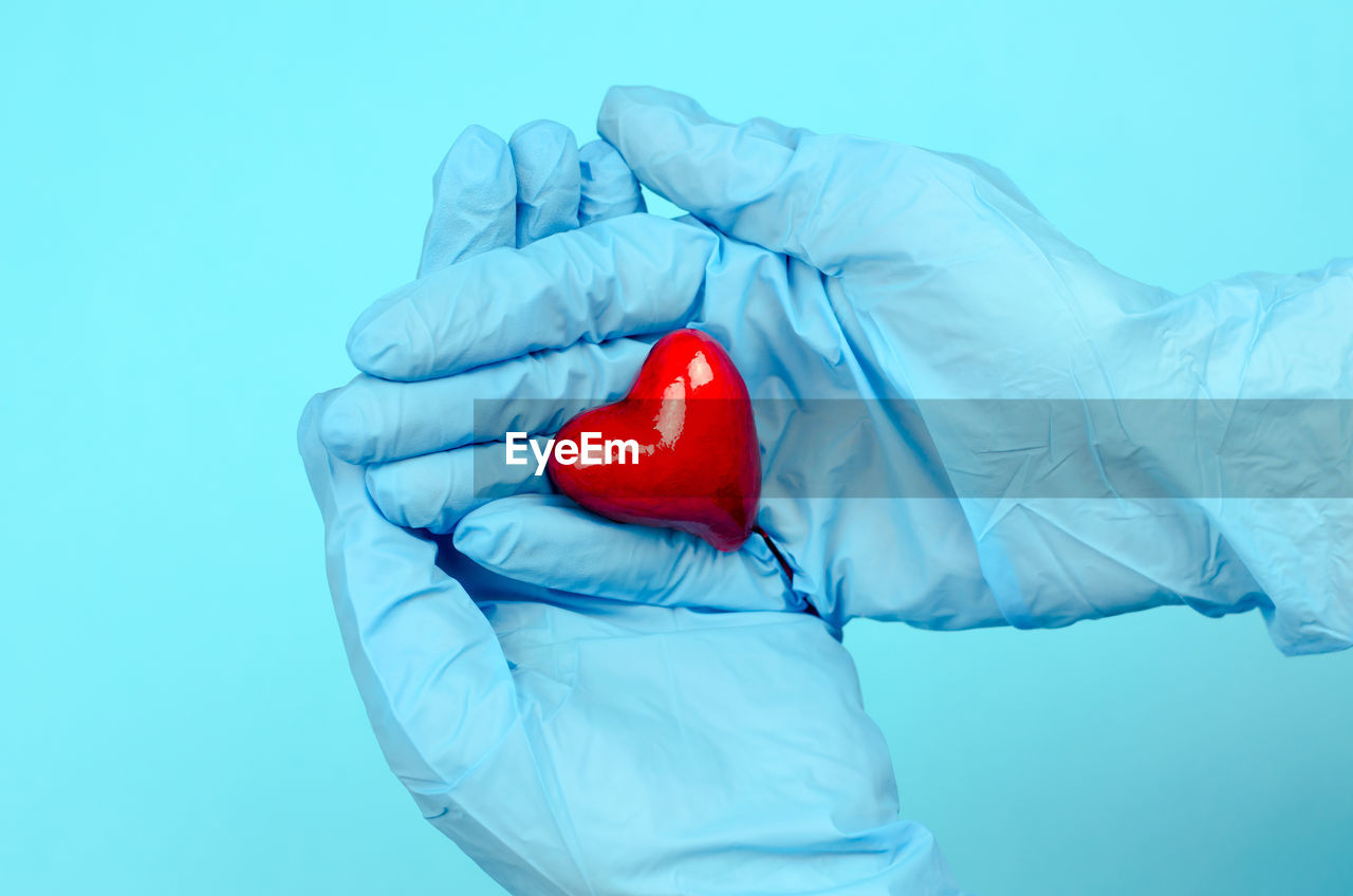 CLOSE-UP OF MAN HOLDING HEART SHAPE