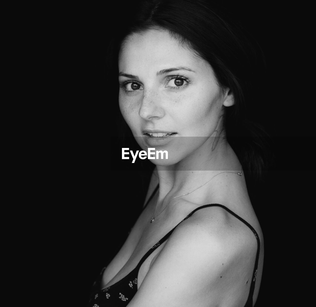 Close-up portrait of woman against black background