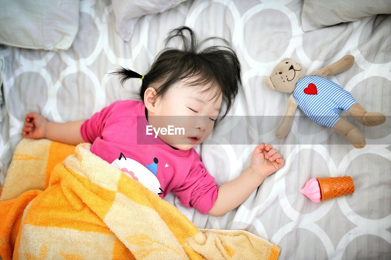 PORTRAIT OF CUTE BABY GIRL LYING ON BED