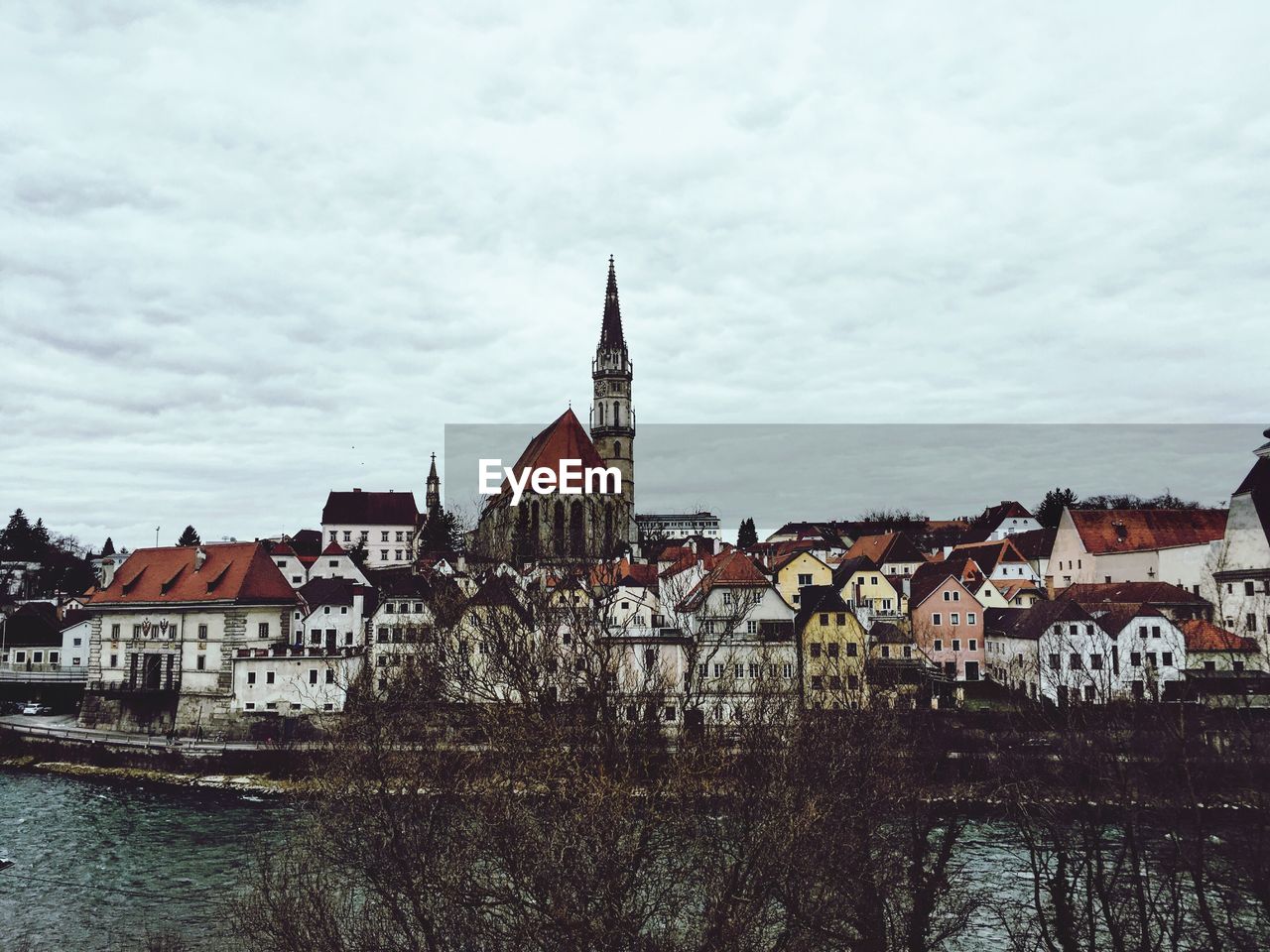 Buildings in city against cloudy sky