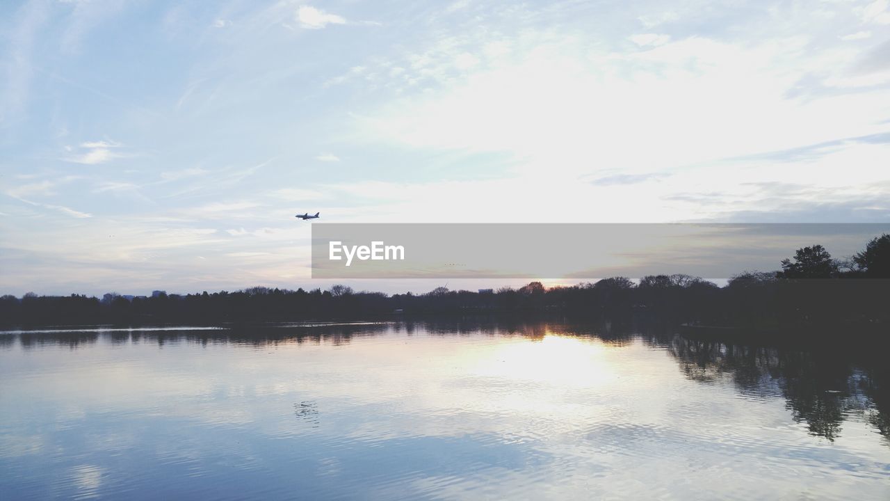 Scenic view of calm lake against cloudy sky