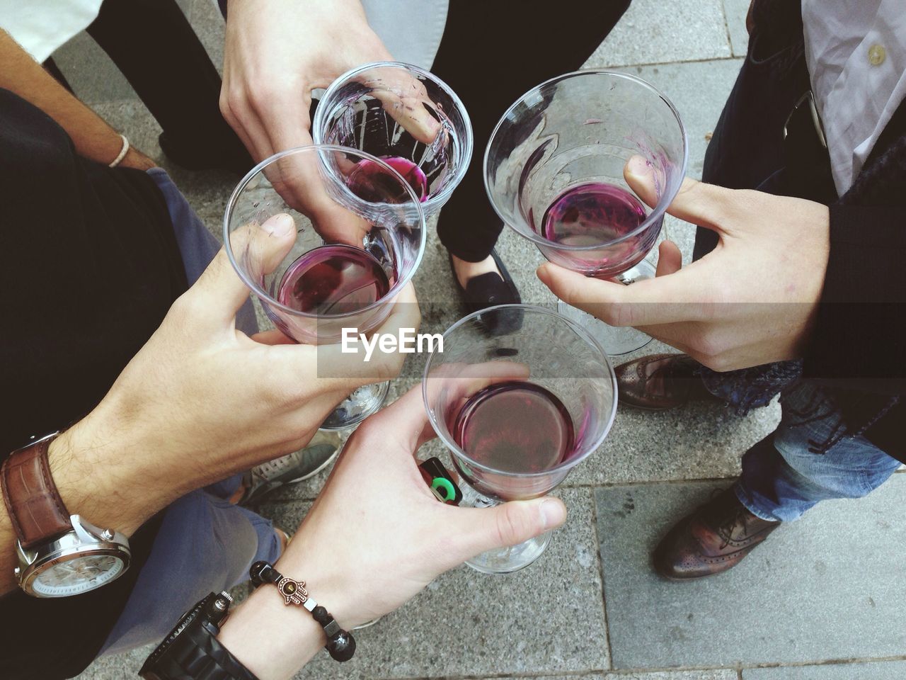 High angle view of people holding glasses with drink on street
