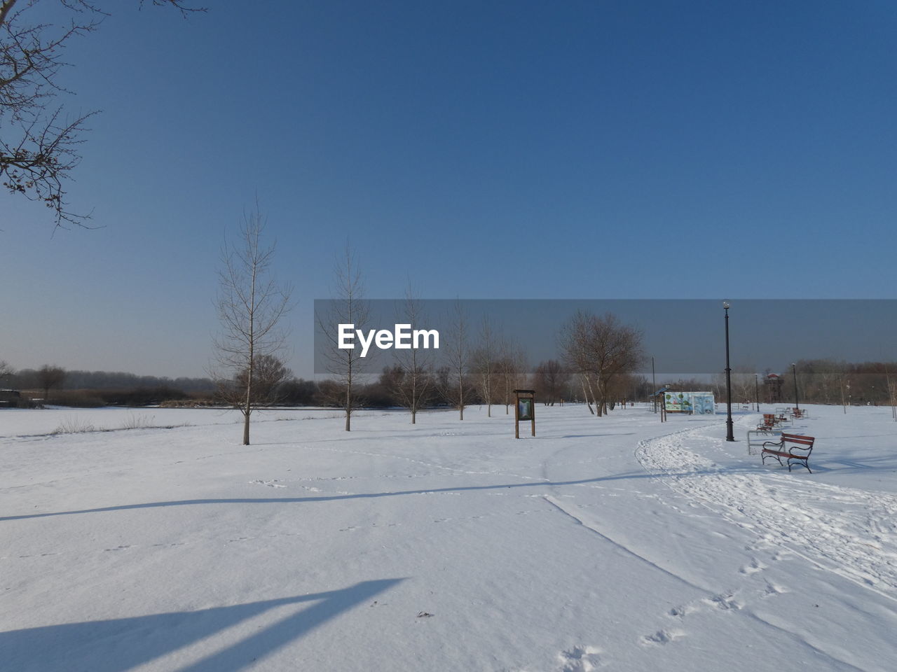 Snow covered field against clear sky