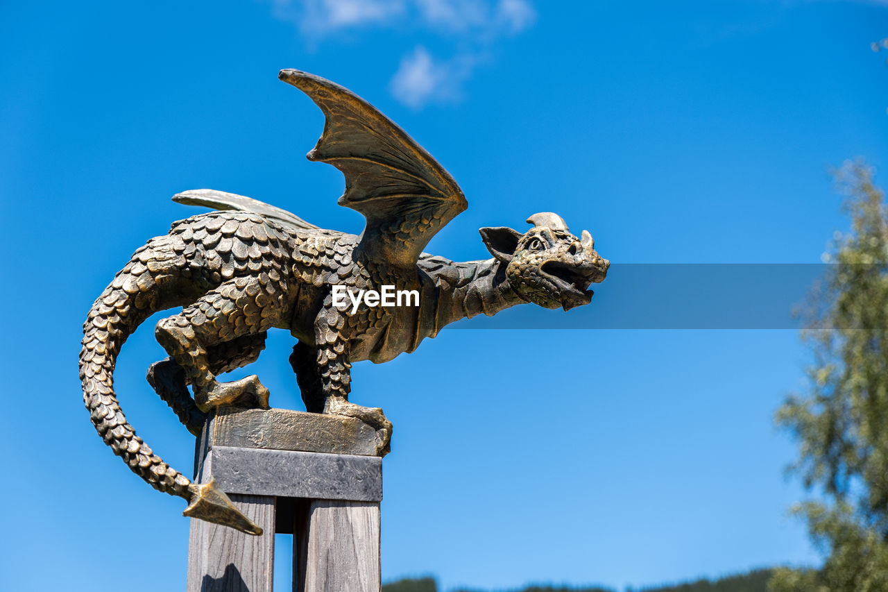 LOW ANGLE VIEW OF A STATUE AGAINST BLUE SKY