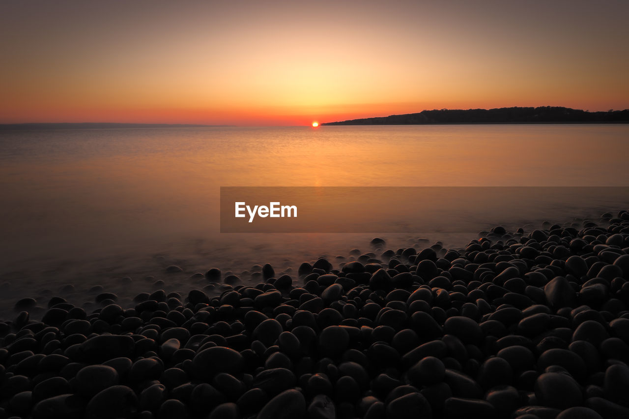 sky, horizon, water, sea, sunset, beauty in nature, scenics - nature, nature, tranquility, dawn, beach, horizon over water, land, coast, tranquil scene, ocean, orange color, sun, silhouette, no people, idyllic, shore, afterglow, sunlight, environment, evening, dramatic sky, cloud, outdoors, seascape, landscape, travel destinations, wave, non-urban scene