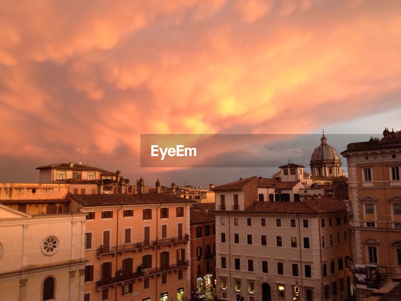 Buildings against cloudy sky at sunset