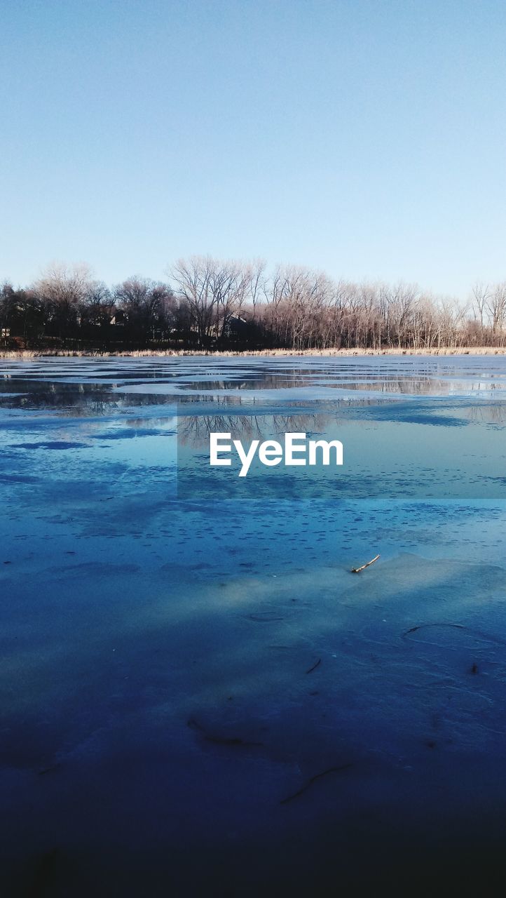 SCENIC VIEW OF FROZEN LAKE AGAINST CLEAR SKY