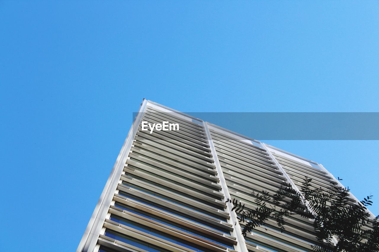 Low angle view of modern building against clear blue sky