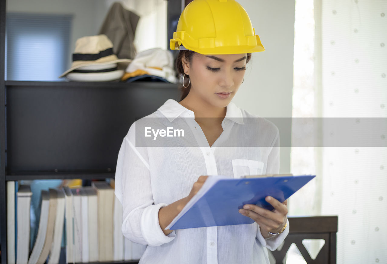 MIDSECTION OF WOMAN WORKING IN A ROOM