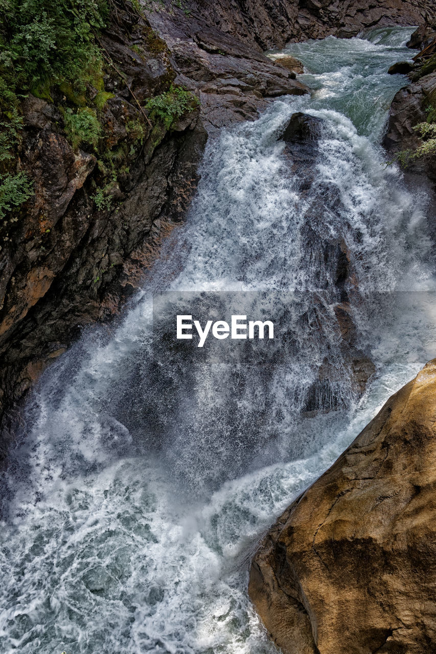 SCENIC VIEW OF WATERFALL ON ROCKS