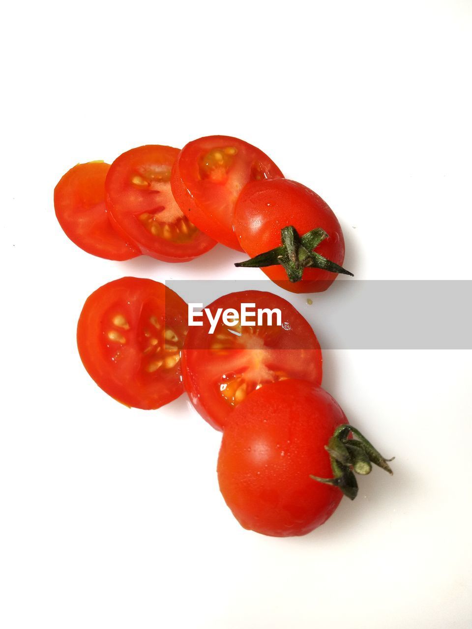 CLOSE-UP OF TOMATOES AGAINST WHITE BACKGROUND