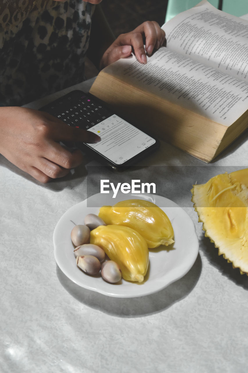 HIGH ANGLE VIEW OF WOMAN PREPARING FOOD IN PLATE