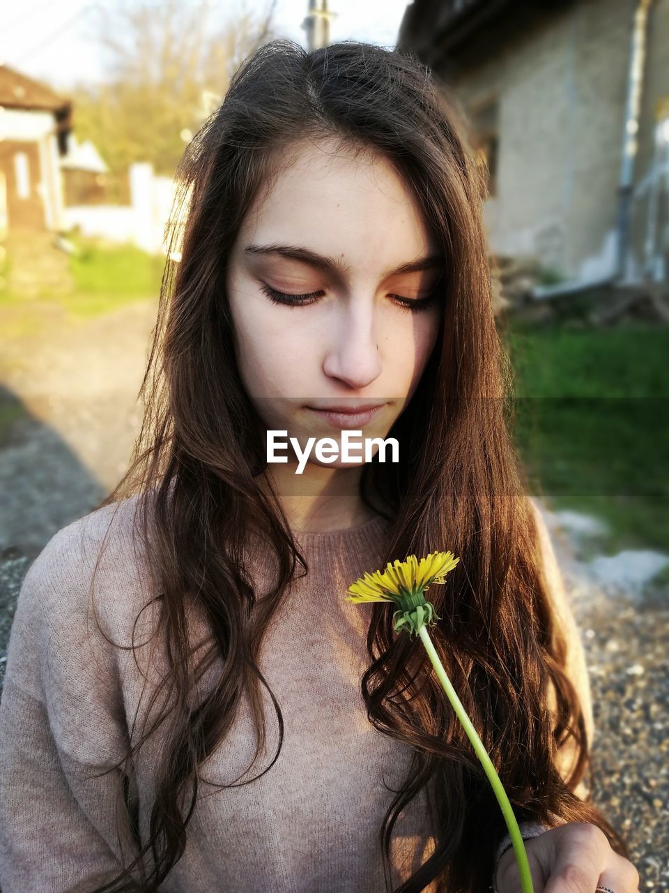 Young woman with long hair holding flower