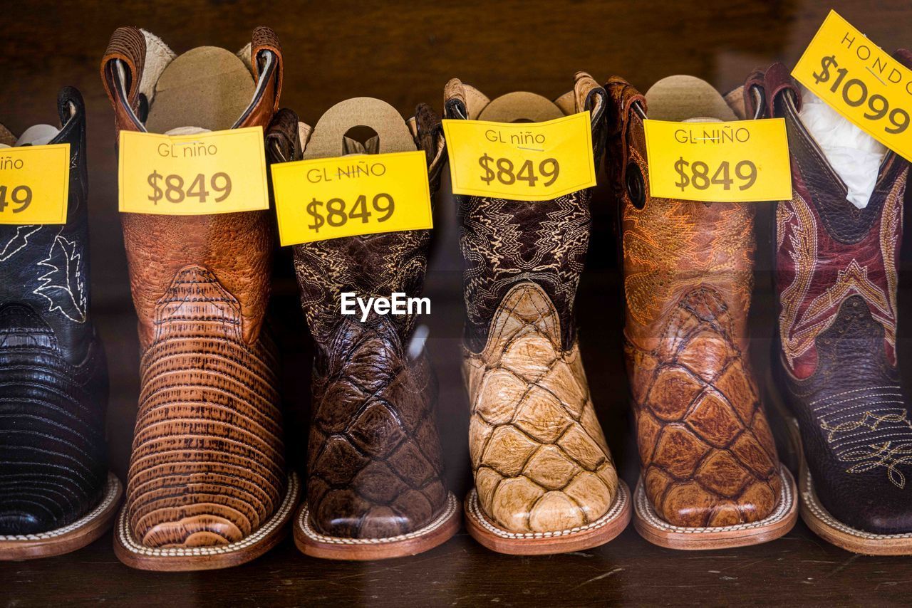 Cowboy boots and leather belts in a business showcase . saddlery, footwear and accessories.