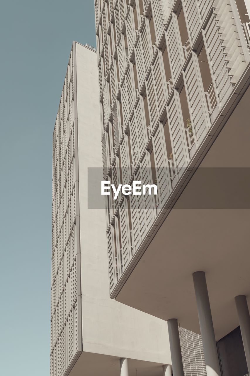 LOW ANGLE VIEW OF MODERN BUILDINGS AGAINST CLEAR SKY