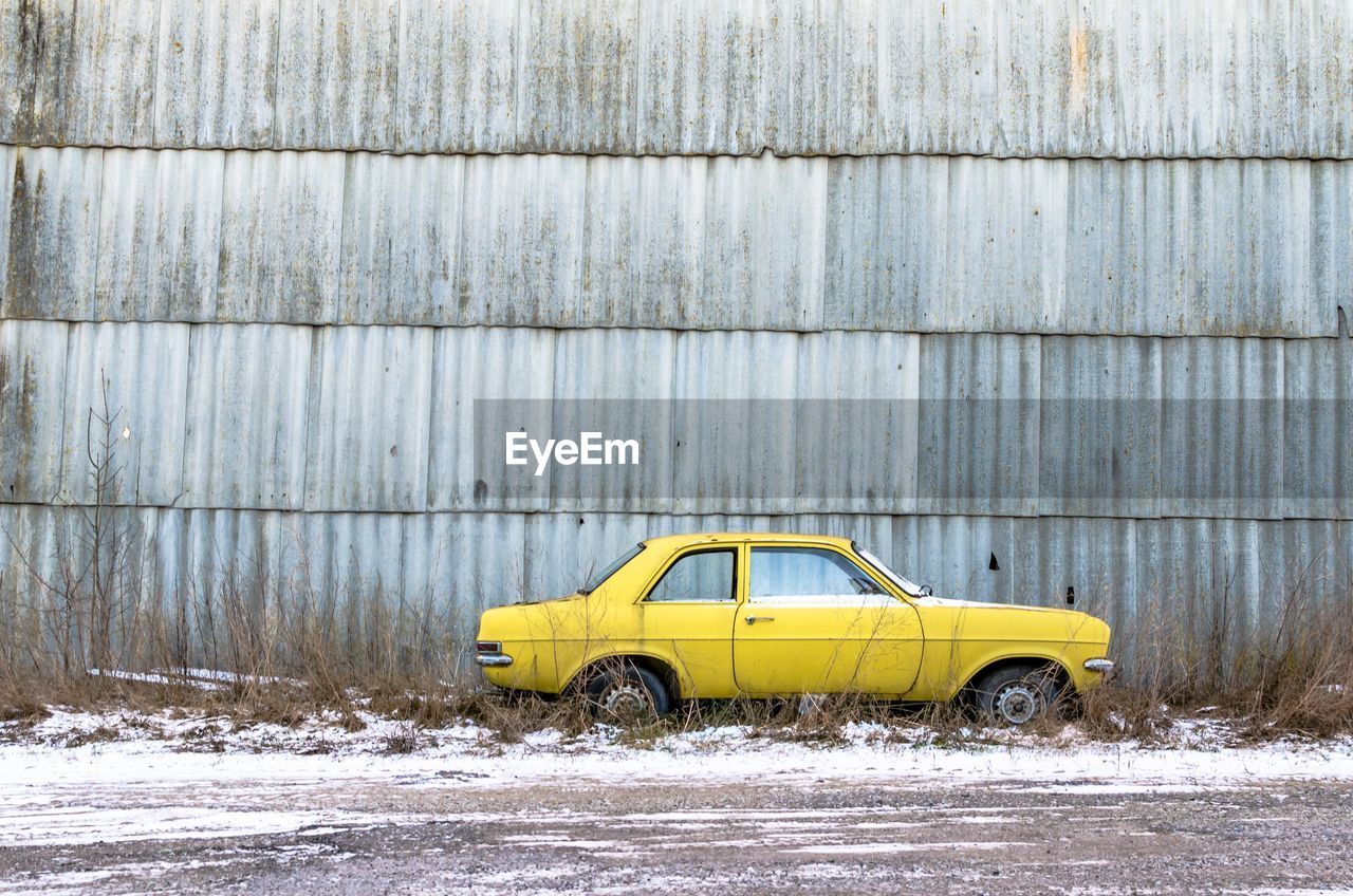 YELLOW CAR ON SNOW COVERED ROAD