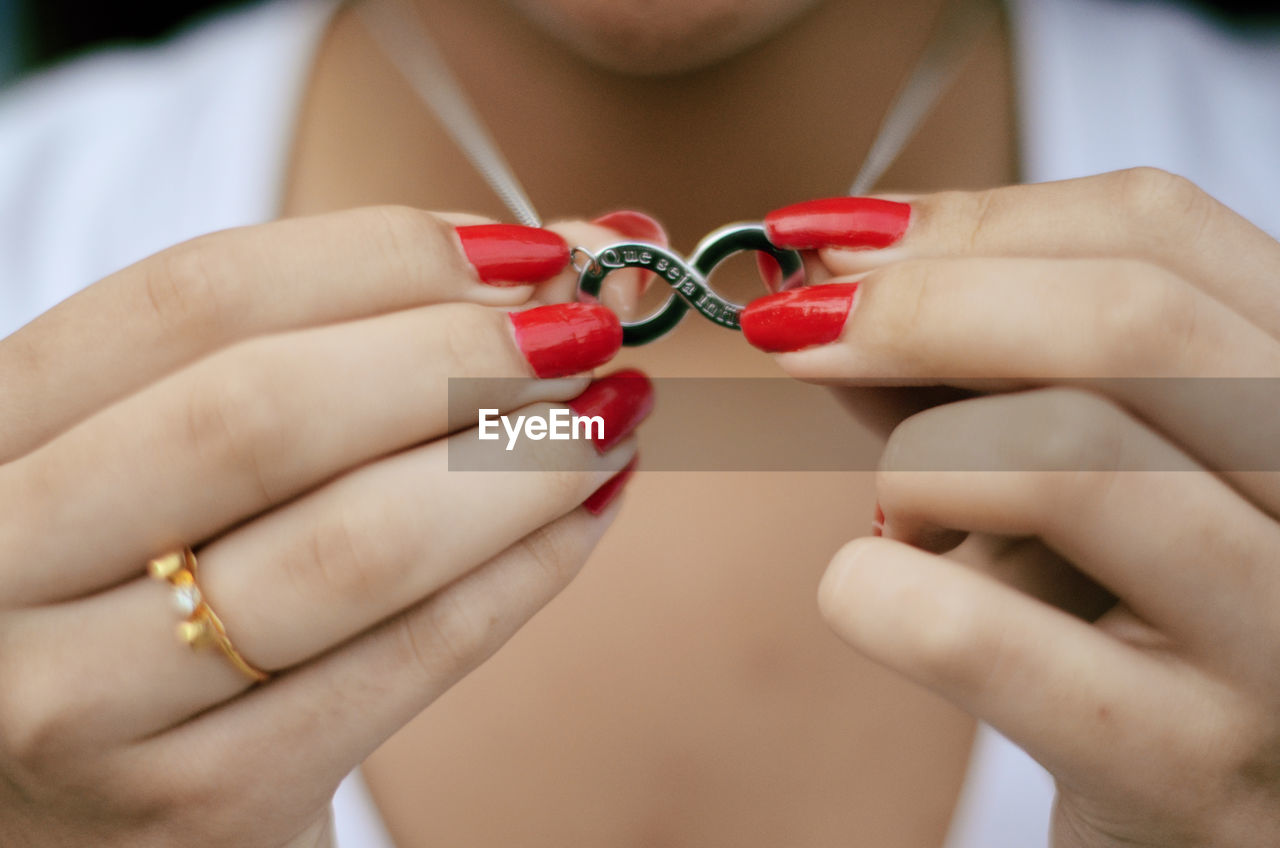 Midsection of woman holding infinity symbol