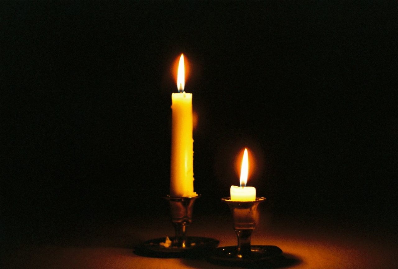 LIT CANDLE IN DARK ROOM