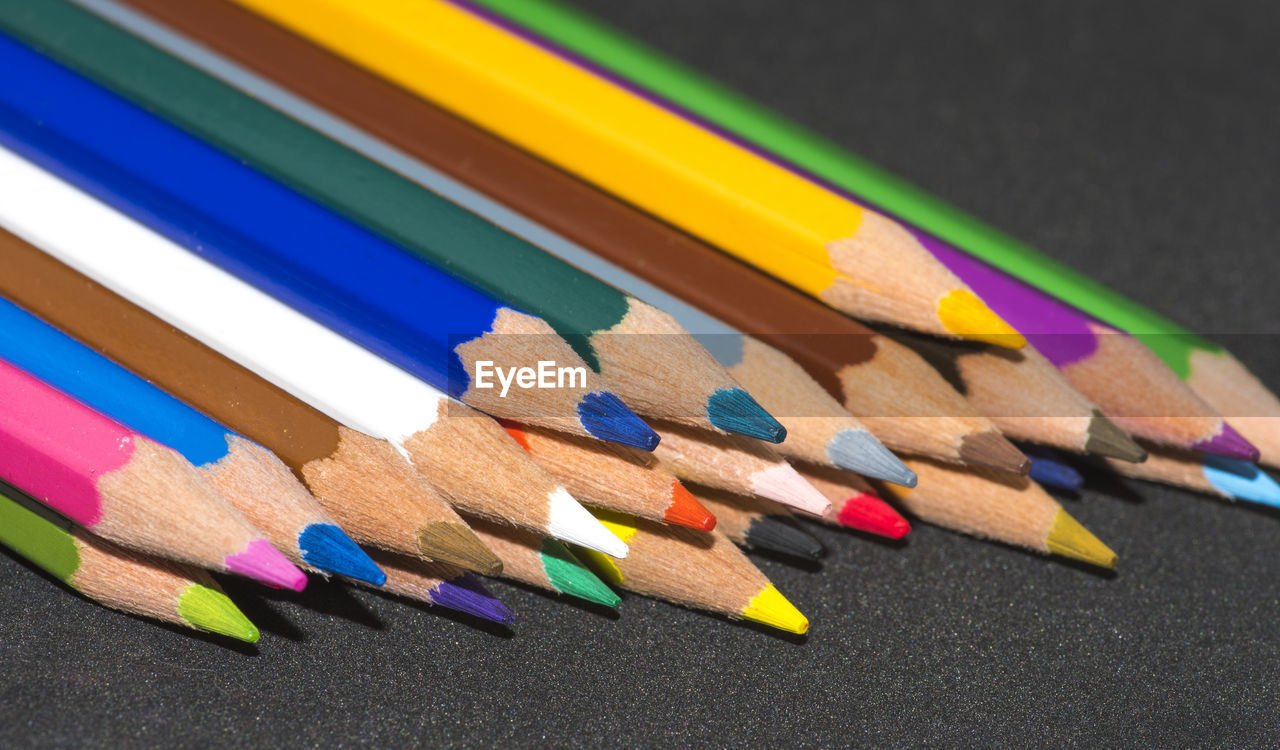 HIGH ANGLE VIEW OF MULTI COLORED PENCILS ON SHELF