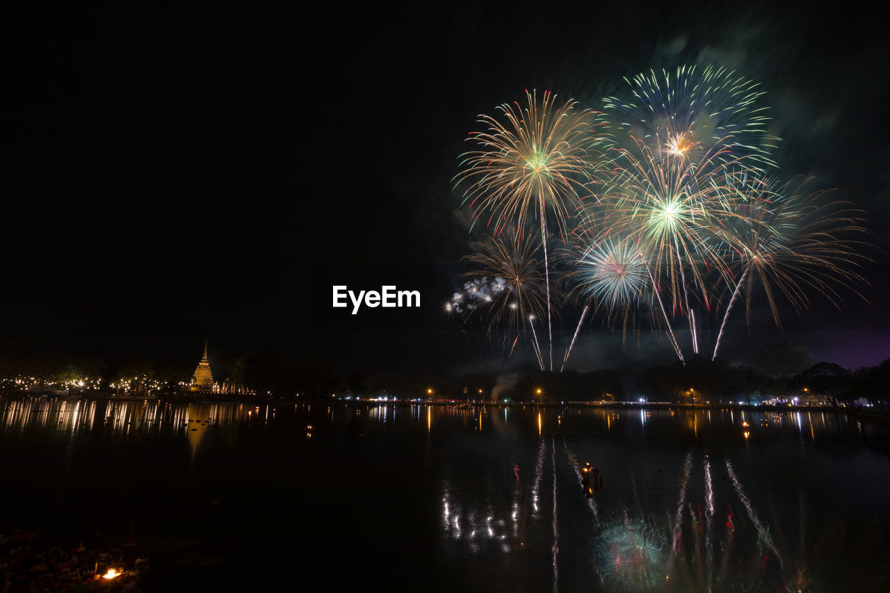 FIREWORK DISPLAY OVER WATER AT NIGHT