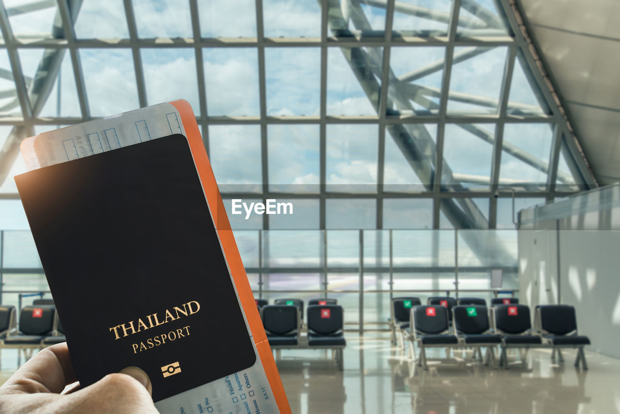 airport, communication, indoors, airport departure area, travel, technology, hand, one person, transportation, journey, text, adult, architecture, sign, airport terminal, holding, business, mode of transportation, glass, day