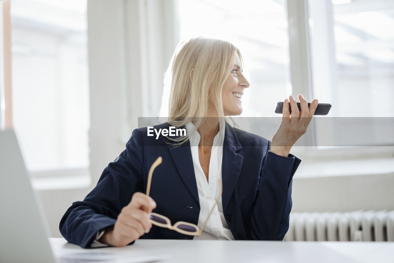 Businesswoman using cell phone in office