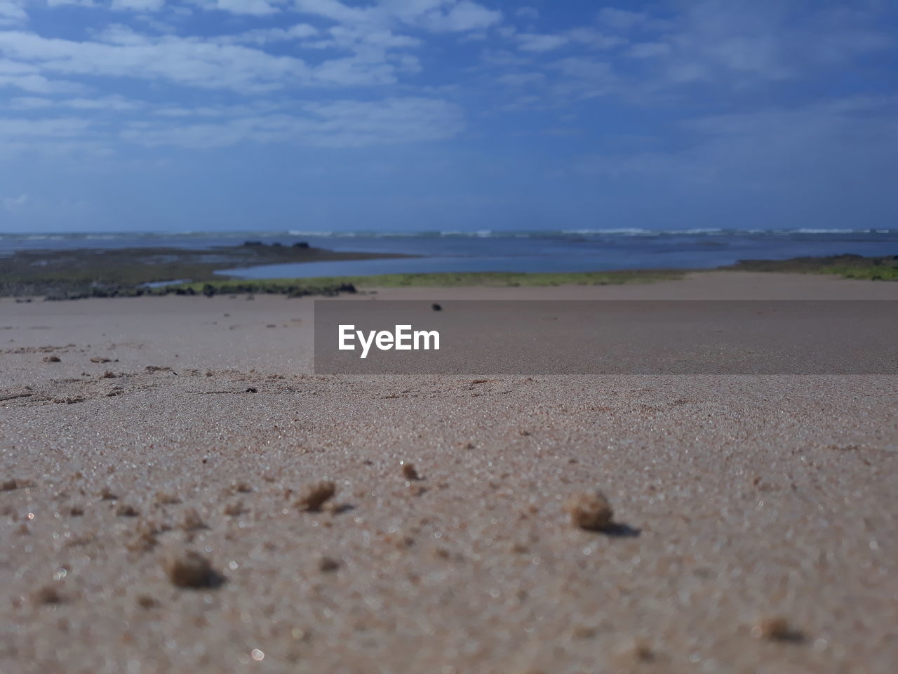 SURFACE LEVEL OF SAND ON BEACH AGAINST SKY