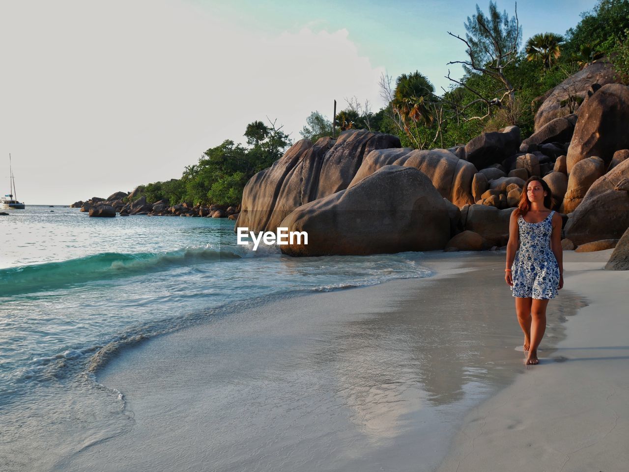 Full length of woman walking on beach against sky