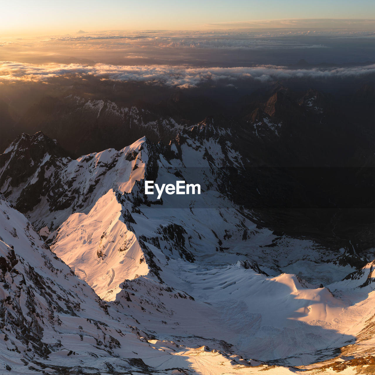 Aerial view of snowcapped mountains against sky during sunset