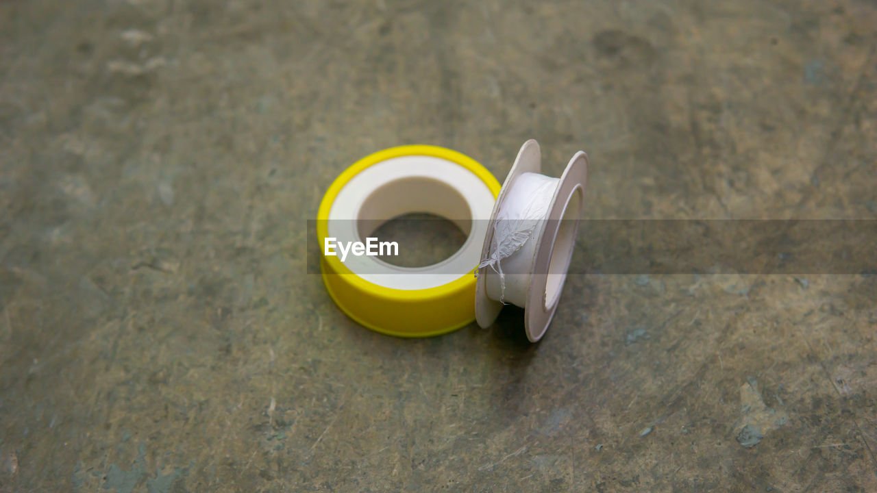 HIGH ANGLE VIEW OF COFFEE CUP ON TABLE AGAINST YELLOW BACKGROUND